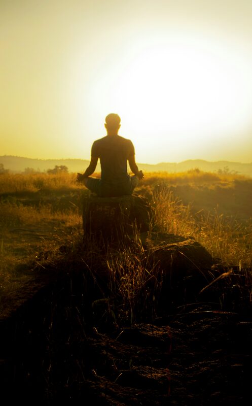 Figure in meditation at golden sunrise